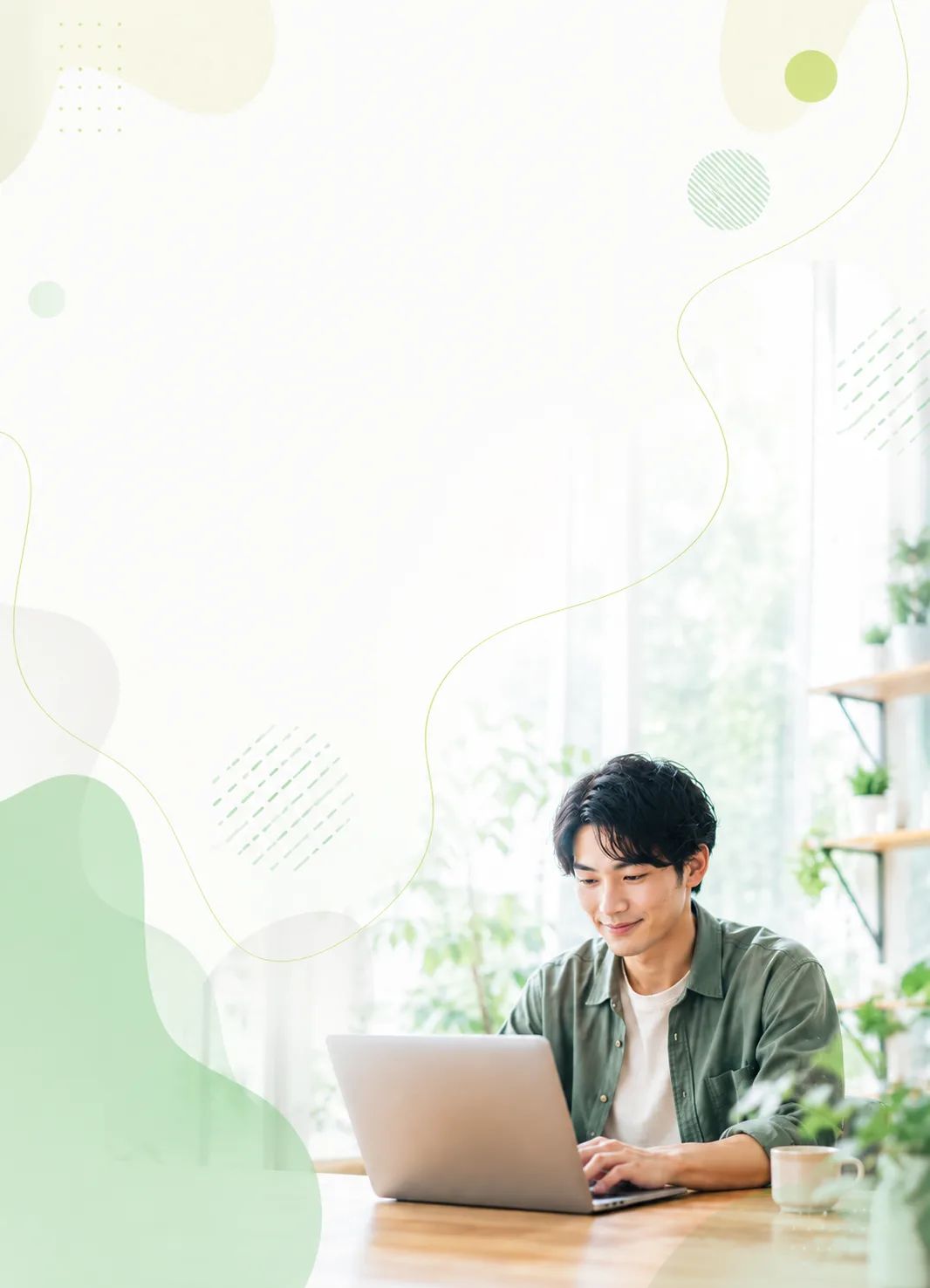自宅のデスクでノートPCに向かう男性